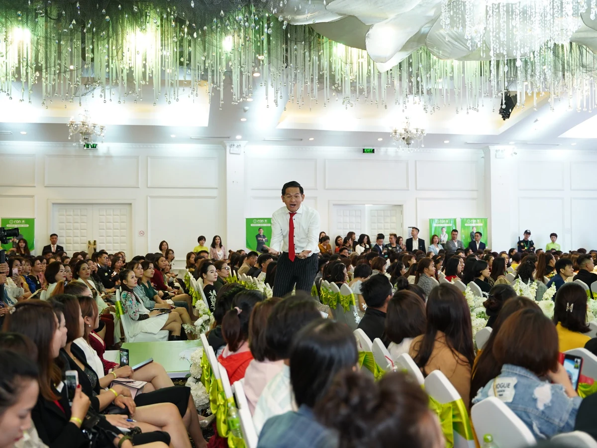 Diễn giả đứng giữa các hàng ghế, trao đổi cùng học viên trong hội trường.